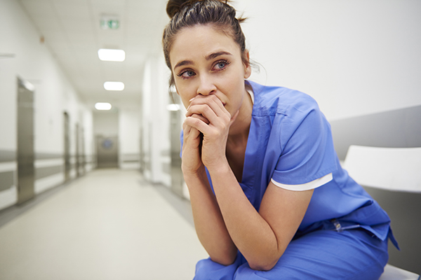 Worried and stressed doctor sitting on corridor