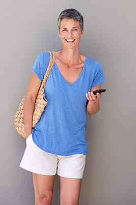 happy middle aged woman holding cellphone